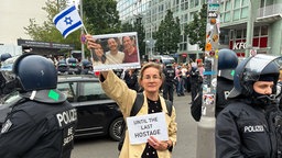 Polizisten stehen neben Karoline Preisler, Berliner FDP-Politikerin und Aktivistin, während einer propalästinensischen Demonstration am Checkpoint Charlie