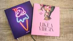 Bücher Hubertus Tschirners "Eis" und Linh Nguyens "Like A Virgin – die Mocktail-Bibel" liegen nebeneinander auf einem Tisch. 