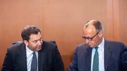 Bundeskanzler Friedrich Merz (r,CDU) spricht neben Lars Klingbeil (SPD), Bundesminister der Finanzen, zu Beginn der Sitzung des Bundeskabinett im Kanzleramt.
