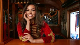 Das Porträt von Lili Paul‑Roncalli zeigt sie mit freundlichem Lächeln in einer rot‑goldenen Zirkusuniform.
