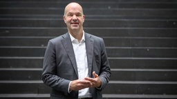 Ökonom Marcel Fratzscher steht auf einer Treppe und lächelt in die Kamera. 