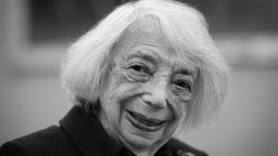 Das schwarz-weiß Porträt von Margot Friedländer zeigt sie mit weißem Haar, aufgeschlossenen Augen und einem breiten, freundlichen Lächeln.