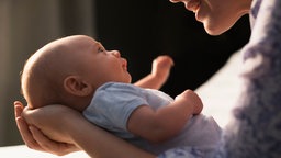 Mutter lächelt ihr Baby an 