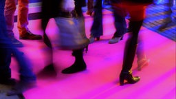 Durch Bewegung verschwommene Beine, Stiefel und Neon-Farben.