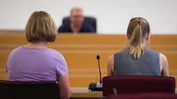 Symbolbild psychosoziale Prozessbegleitung: Eine Frau begleitet eine Frau bei einer Aussage in einem Gerichtsprozess