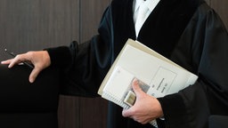 Nahaufnahme eines Richters in Robe mit Akten in der Hand.
