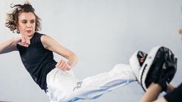 Eine junge Frau trainiert asiatische Kampftechniken
