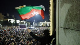 Ein Student schwenkt eine bulgarische Flagge, während Zehntausende Bulgaren demonstrieren.  