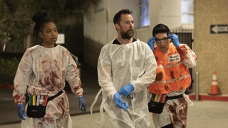 Noah Wyle in seiner Rolle als Dr. Michael "Robby" Robinavitch in der Serie The Pitt; zusammen mit weiterem Krankenhauspersonal ist er zu Fuß auf dem Weg zu einem medizinischen Notfall.