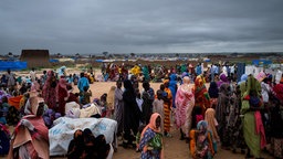 „Etwa hundert Menschen, die über Nacht die Grenze überquert haben, warten vor dem Registrierungszentrum des Flüchtlingshilfswerks der Vereinten Nationen (UNHCR) im Transitlager Adre in der Wadai-Region im Tschad.