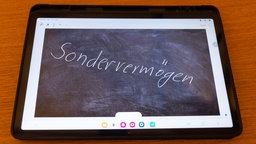 Auf einem Tablet steht in Schiefertafeloptik das Wort "Sondervermögen"