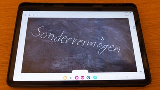 Auf einem Tablet steht in Schiefertafeloptik das Wort "Sondervermögen"