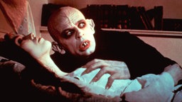 Klaus Kinski kauert in seiner Rolle als Nosferatu über Lucy Harker, gespielt von Isabelle Adjani.