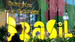 Ein Teilnehmer des UN-Klimagipfels COP29 geht an einem Schild mit der Aufschrift "Wir sehen uns bei COP30" vorbei, der in Brasilien stattfinden wird.
