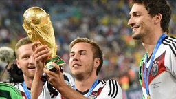 Mario Götze hält den WM-Pokal nach dem Finalsieg der deutschen Mannschaft in Argentinien 2014