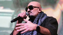 Rapper Xatar singt auf einer Bühne (2024).