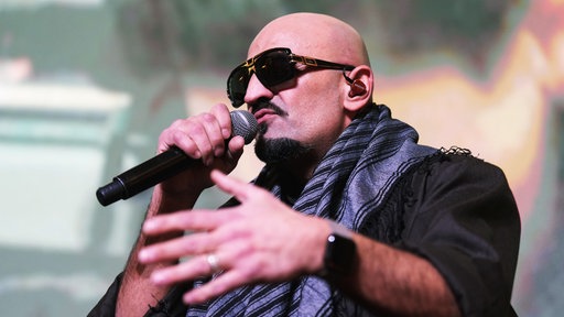 Rapper Xatar singt auf einer Bühne (2024).
