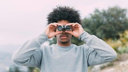 Ein Mann schaut durch ein Fernglas
