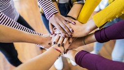 Menschen legen die Hände aufeinander