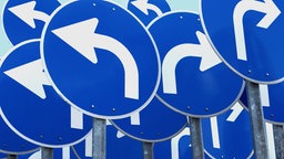 Blaue Straßenschilder mit pfeilen zeigen in verschiedene Richtiungen