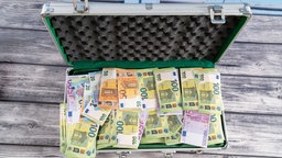 Geöffneter Metallkoffer mit vielen Geldscheinen