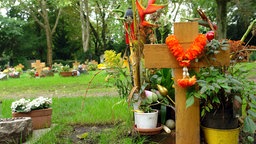 Ein frisches Grab mit Blumen auf einem Friedhof 