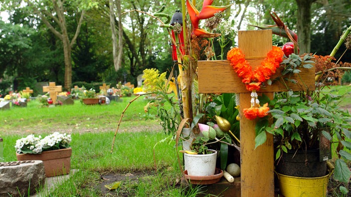 Ein frisches Grab mit Blumen auf einem Friedhof 