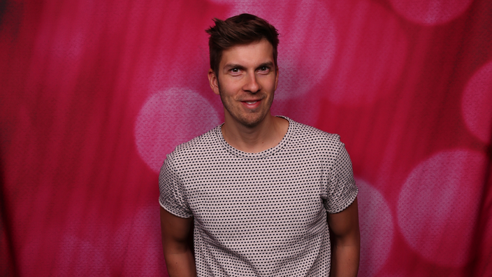 Simon Stäblein vor einem rosa Hintergrund