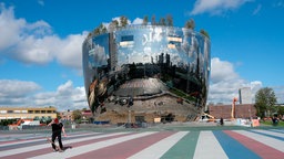 Eion Skateborder auf dem Platz vor der spiegelnden Fassade des kunstvoll gestalteten Kunstdepots Boijmans Van Beuningen.