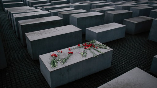 Nelken liegen auf einer Stehle des Holocaust Denkmals in Berlin