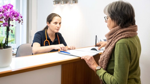 Eine Patientin wird in einer Praxis in Flensburg von einer Sprechstundenhilfe beraten. 