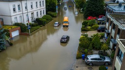 Autos stehen in den Wassermassen in einer überschwemmten Straße in Mönchengladbach-Rheydt.