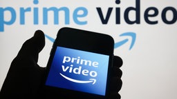 Illustrationsfoto mit Prime Video-Symbol auf einem Handybildschirm und die Prime Video-Website auf einem Laptop-Bildschirm.