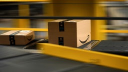 Amazonpakete liegen auf dem Transportband im Logistik Zentrum.