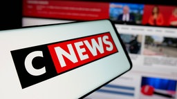 Auf dem Bildschirm ist vor der Website ein Smartphone mit dem Logo des französischen Nachrichten- und Medienunternehmens CNews zu sehen, 25.04.2025.