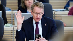 Daniel Günther (CDU), Ministerpräsident von Schleswig-Holstein, hebt die Hand während einer Abstimmung im Landtag, 10.12.2025. 