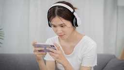Mädchen spielt ein Videospiel auf einem Smartphone.