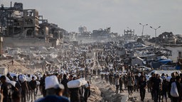 Palästinenser tragen Mehlsäcke, die sie am Grenzübergang Zikim in Gaza von Lastwagen beschlagnahmt hatten, 31.07.2025. 