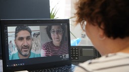 Isabel Schayani und Bamdad Esmaili sprechen über einen Laptop mit einer Kollegin. 