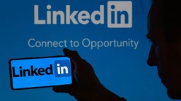 LinkedIn-Logo wird auf einem Smartphone angezeigt, im Hintergrund ist der Schriftzug "LinkedIn - Connect to Opportunity"  sichtbar, Brüssel, Belgien, 03.06.2024.