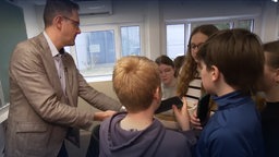 Schulleiter Sven Hees sammelt die von Schülern freiwillig abgegebenen Smartphones ein, Nicolaus-Cusanus-Gymnasium, Bergisch Gladbach. 