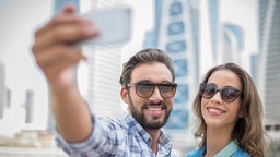 Touristenpaar macht Smartphone-Selfie, Dubai, Vereinigte Arabische Emirate.