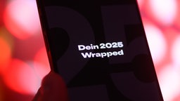 Schriftzug "Dein 20225 Wrapped" ist innerhalb der App des Musik-Streaminganbieters Spotify auf einem Smartphone zu sehen, 02.12.2025.