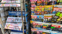 Auslage zeigt Tageszeitungen, Boulevardzeitungen und Fachzeitschriften in einem Kiosk.
