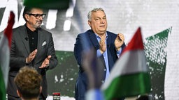 Viktor Orban auf der Bühne beim bei einer Versammlung der "Digital Civic Circles" am 6. Dezember 2025. Das Publikum hält ungarische Flaggen.