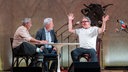 Das Kabarett-Trio "Wir Staatskünstler" sitzt beim Salzburger Stier 2026 an einem Tisch auf der Bühne