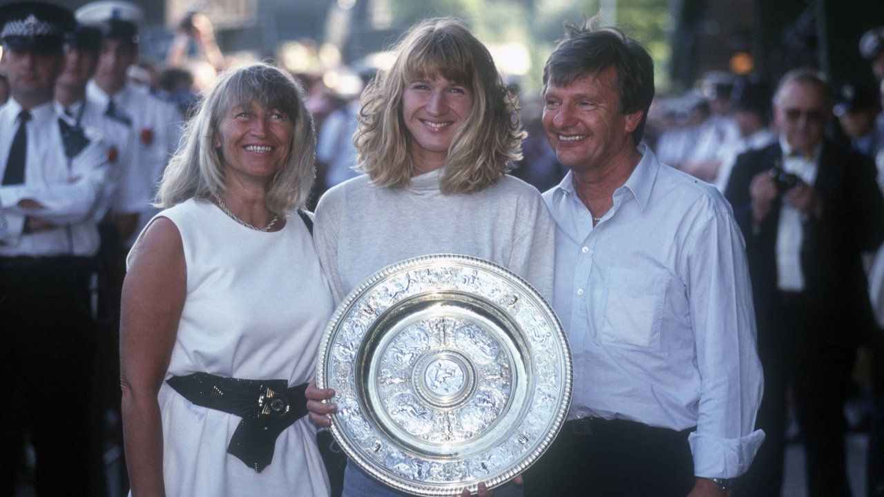 Steffi Graf präsentiert 1991 die Wimbledon-Trophäe gemeinsam mit ihren Eltern Heidi und Peter