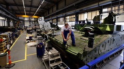 Ein Mann arbeitet an einem Panzer 