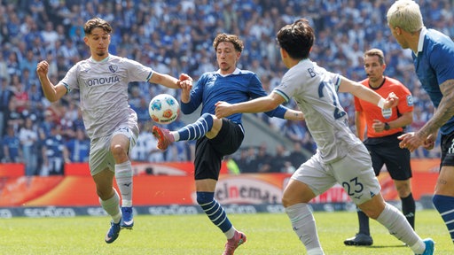Jannik Rochelt im Kampf um den Ball mit Cajetan Lenz und Koji Miyoshi 