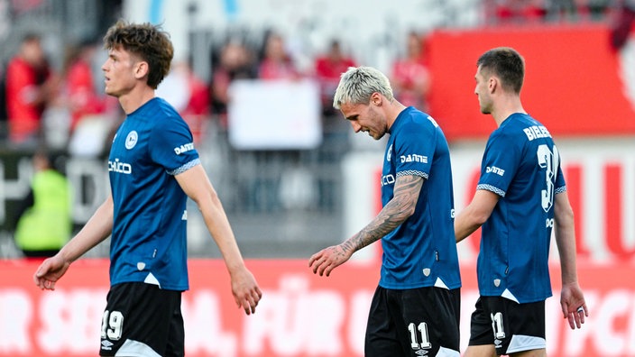 Maximilian Großer (l-r, Arminia Bielefeld), Joel Grodowski (Arminia Bielefeld) und Robin Knoche (Arminia Bielefeld) verlassen enttäuscht das Spielfeld
